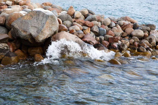 Piedras en la playa del mar. Día de invierno de pastos. Agua clara y arena. Kirguistán, lago Issyk-Kul — Foto de Stock