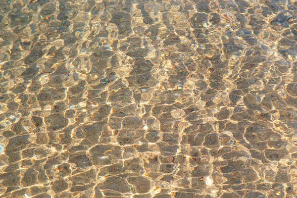 Textura de água clara em azul. Fundo do oceano e do mar iluminado pelo sol. Água natural — Fotografia de Stock