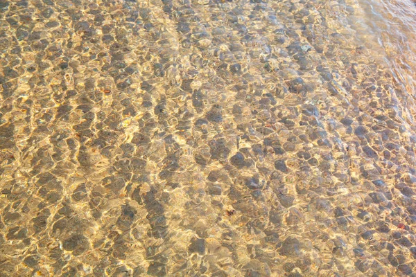 Klare Wasserstruktur in Blau. Hintergrund des Ozeans und des Meeres im Gegenlicht der Sonne. natürliches Wasser — Stockfoto