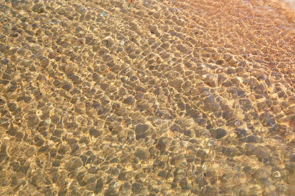 Heldere watertextuur in blauw. Achtergrond van de oceaan en de zee verlicht door de zon. Natuurlijk water — Stockfoto