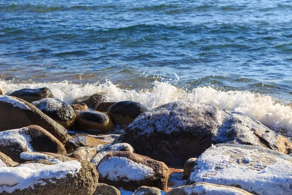 Piedras en la playa del mar. Día de invierno de pastos. Agua clara y arena. Kirguistán, lago Issyk-Kul — Foto de Stock