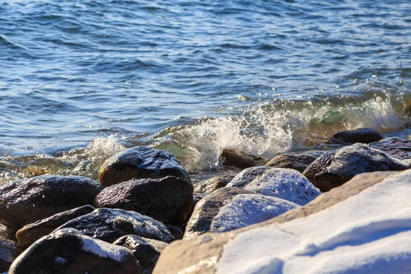 Piedras en la playa del mar. Día de invierno de pastos. Agua clara y arena. Kirguistán, lago Issyk-Kul — Foto de Stock