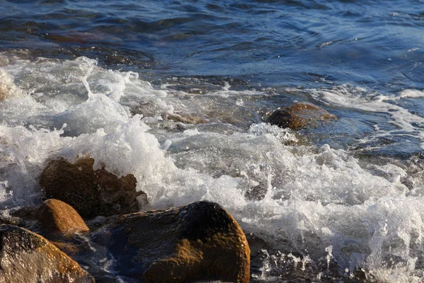 Piedras en la playa del mar. Día de invierno de pastos. Agua clara y arena. Kirguistán, lago Issyk-Kul — Foto de Stock