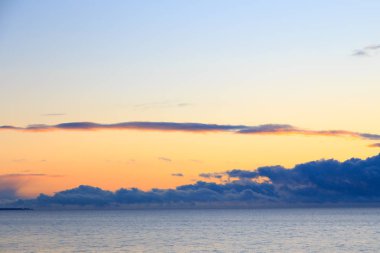 Pink vanilla heaven. Bright blue sky with gentle cumulus clouds. Above the sea