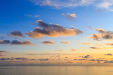 Pink vanilla heaven. Bright blue sky with gentle cumulus clouds. Above the sea