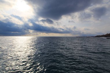 Winter beach. Blue clear sea water. View from the sea to the shore. Kyrgyzstan