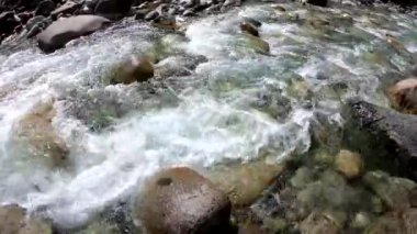 Dağdaki azgın nehirde su. Taşların ve suyun güzel doğal arkaplanı.