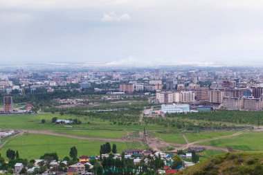 Dağdan şehrin manzarası. Yaz manzarası. Kırgızistan, Bişkek. Binalar ve mimari