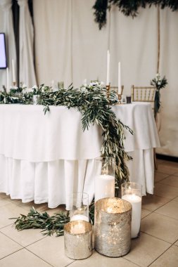 Beyaz düğün tablo dekore edilmiş çiçekler ve okaliptüs, tabak, bardak