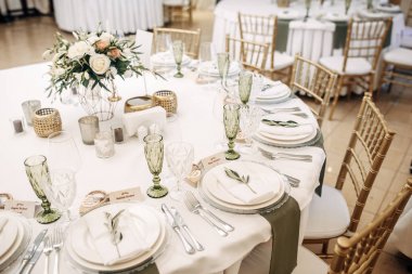 Beyaz düğün tablo dekore edilmiş çiçekler ve okaliptüs, tabak, bardak