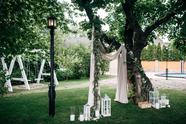 Ingerichte ruimte met witte bruiloft boog houten kaars lampen en bloemen — Stockfoto