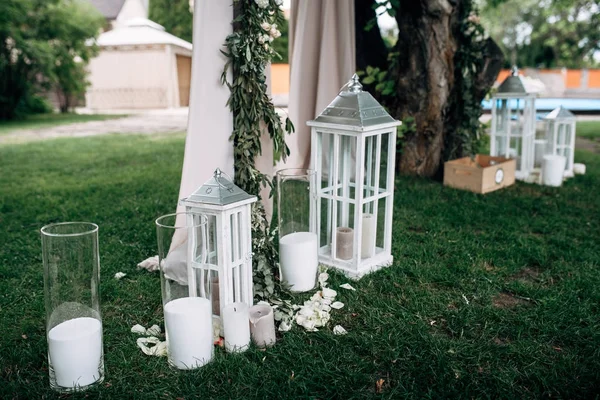 Zone décorée avec arc de mariage blanc lampes à bougie en bois et fleurs — Photo