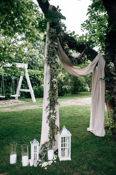 beyaz düğün kemer ahşap mum lambalar ve çiçeklerle süslü alan