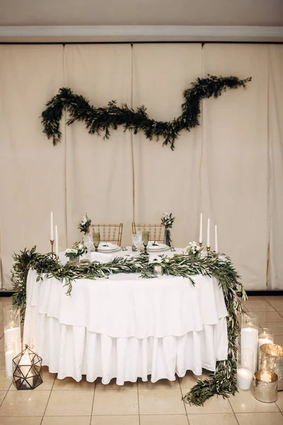Білий весільний стіл, прикрашений квітами та евкаліптом, тарілками, окулярами — стокове фото