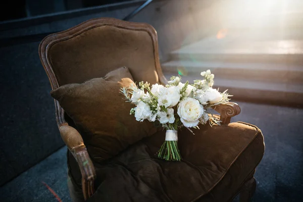 Красивый букет белых цветов, лежащий на коричневом легком стуле — стоковое фото