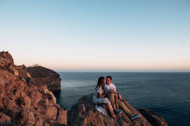 gün batımı kayalık arazide sarılma, genç mutlu çift