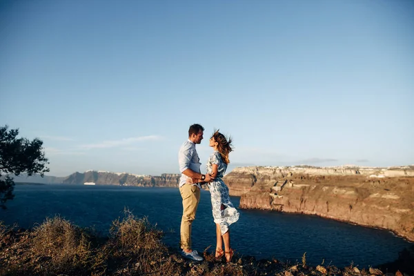 Unga lyckliga paret på solnedgången kramar i stenig terräng — Stockfoto