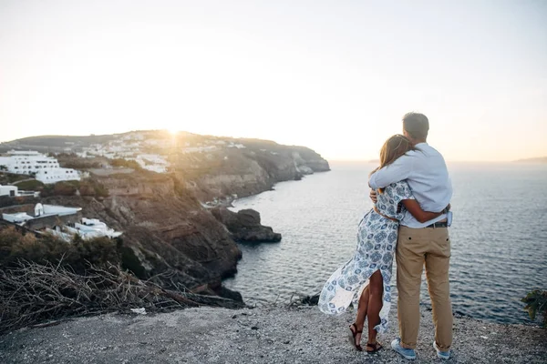 Joven feliz pareja al atardecer abrazándose en terreno rocoso —  Fotos de Stock