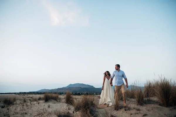 Красивая пара ходьба, держась за руки на песке — стоковое фото
