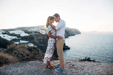 Genç çift Santorini görünümü ile sarılma