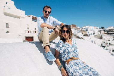 Çift Santorini'de, çatıda oturan sarılma ve laug
