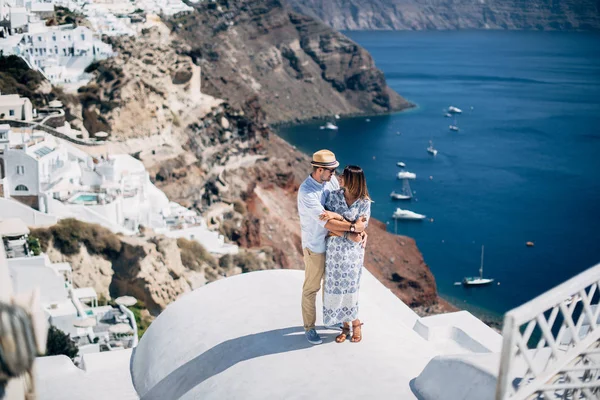 La pareja está de pie en el techo de Santorini — Foto de Stock