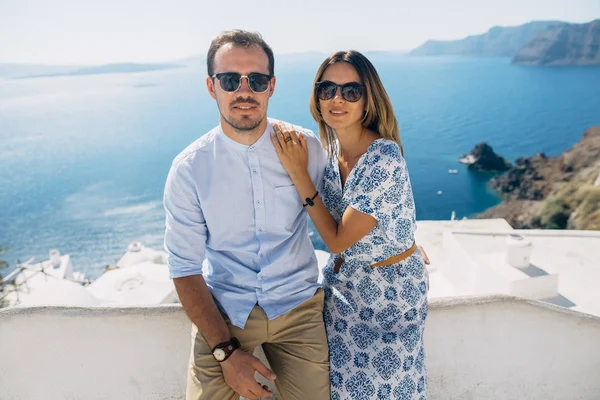 Pareja feliz abrazándose y riendo juntos con una vista de Santorini —  Fotos de Stock