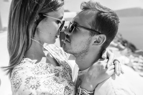 Foto em preto e branco de um jovem casal com vista para o mar, eles se olham nos olhos — Fotografia de Stock