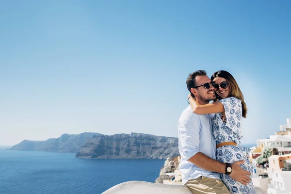 Couple heureux embrasser et rire ensemble avec une vue de Santorin — Photo