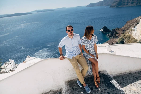 Pareja feliz abrazándose y riendo juntos con una vista de Santorini —  Fotos de Stock