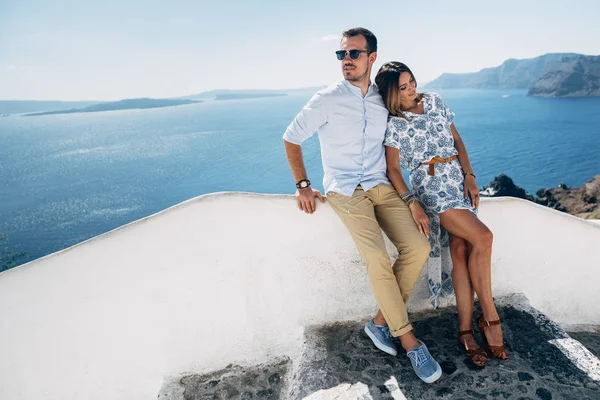 Pareja feliz abrazándose y riendo juntos con una vista de Santorini — Foto de Stock