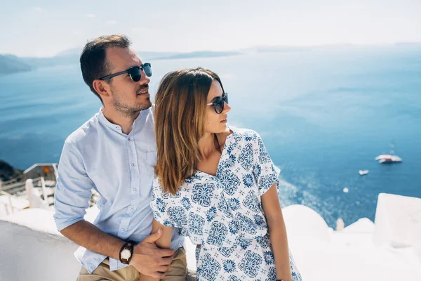 Pareja feliz abrazándose con una vista de Santorini — Foto de Stock