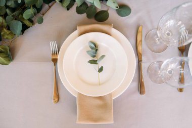 Beyaz ahşap mum lambalar ve çiçekler, çatal ve bıçak ve makara plaka yanında iki kişilik bir düğün masa süslenmiş