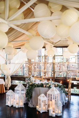 alan beyaz ahşap mum lambalar ve çiçeklerle süslenmiş