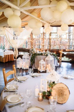 Beyaz ahşap mum lambalar ve çiçekler, çatal ve bıçak ve makara plaka yanında düğün tablo süslenmiş