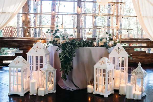 Área decorada con lámparas de vela de madera blanca y flores — Foto de Stock