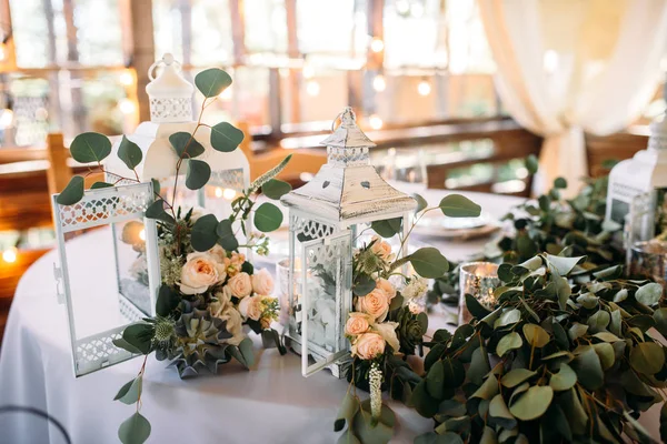 Área decorada com lâmpadas de vela de madeira branca e flores — Fotografia de Stock