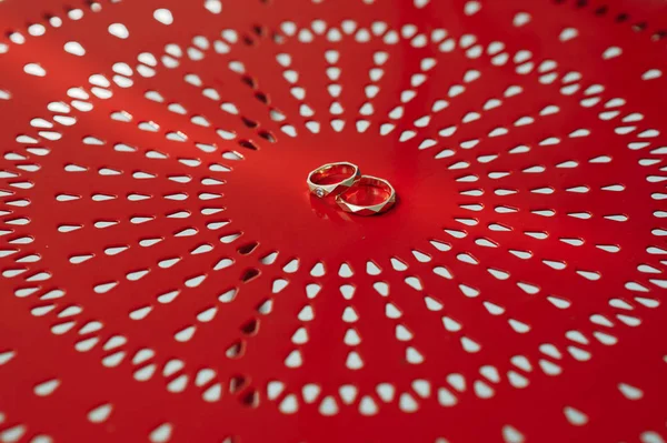 赤い丸椅子の上の結婚指輪 ストック画像