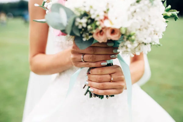 Mains de mariée avec alliance et bouquet de mariage — Photo