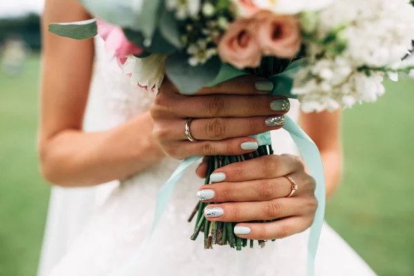Mains de mariée avec alliance et bouquet de mariage — Photo