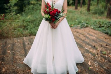 Gelin düğün buket bordo çiçek ve yeşillik ile tutar