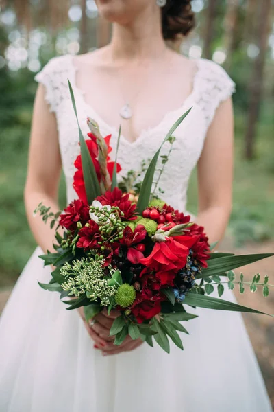 Noiva detém buquê de casamento com flores e verdes borgonha — Fotografia de Stock