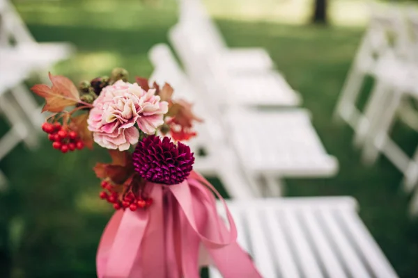 White chairs decorated with purple and pink flowers and ribbons Stock Picture