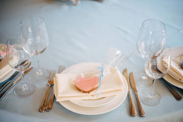 블루 식탁보에 흰색 접시, 접시에 핑크와 파란색 하트 모양 쿠키 — 스톡 사진
