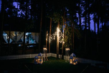 çelenk ışık ampuller çam ağaçları arasında