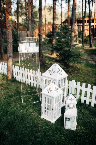 Zone décorée avec des lampes à bougie en bois blanc et des fleurs sur l'herbe — Photo