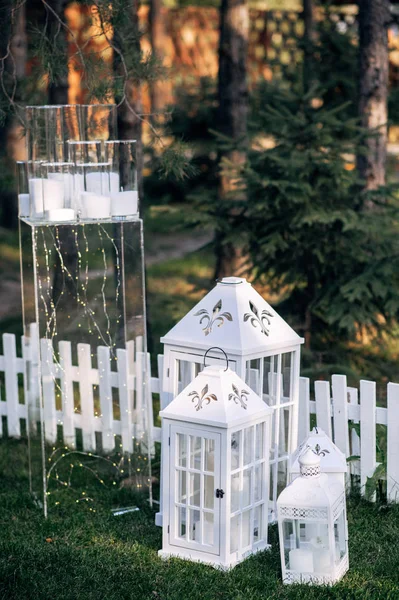 Versierd met witte houten kaars lampen en bloemen op het gras — Stockfoto