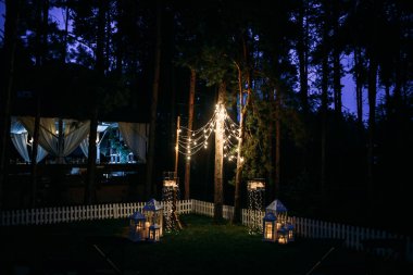 çelenk ışık ampuller çam ağaçları arasında