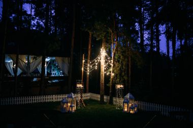 çelenk ışık ampuller çam ağaçları arasında