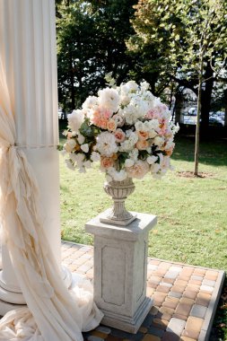 Beyaz düğün kemer beyaz ayakları üzerinde büyük şeftali buketleri ile